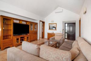 a living room with a couch and a flat screen tv at Villa Kanak in Puerto del Carmen