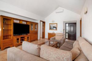 un soggiorno con divano e TV a schermo piatto di Villa Kanak a Puerto del Carmen