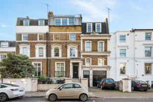 a large brick building with cars parked in front of it at The Grove Apartment in London