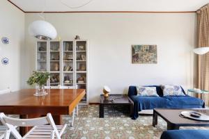 uma sala de estar com um sofá azul e uma mesa em Baia Blu Amati em Lerici
