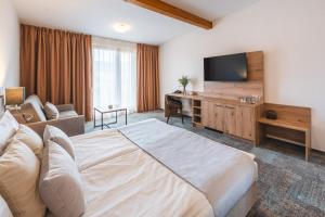 pokój hotelowy z dużym łóżkiem i telewizorem z płaskim ekranem w obiekcie Hotel Kaskáda w mieście Kuřim