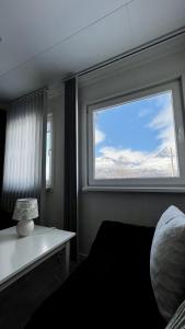 Schlafzimmer mit einem Fenster und Blick auf die schneebedeckten Berge in der Unterkunft Artic Dream in Gratangen