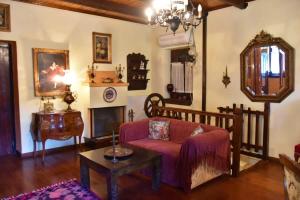 Mariolata Vintage Stone Villa - 4 Season Escape في Marioláta: غرفة معيشة مع أريكة ومدفأة