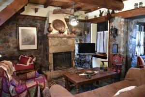 Mariolata Vintage Stone Villa - 4 Season Escape في Marioláta: غرفة معيشة مع أريكة ومدفأة
