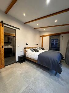 a bedroom with a large bed and a bathroom at De Seuterhoeve in 's-Gravendeel