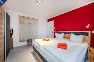 a bedroom with a white bed with a red wall at Ein Traum am Haff in Zirchow