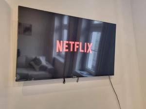 a television on a wall with the words netflix at Altstadt-oase in Cottbus