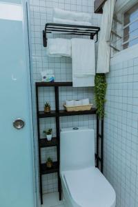 a bathroom with a toilet and towels on a shelf at Neza Haven Kigali in Kigali