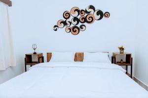 ein Schlafzimmer mit einem weißen Bett mit einem Herz aus Holz in der Unterkunft Neza Haven Kigali in Kigali