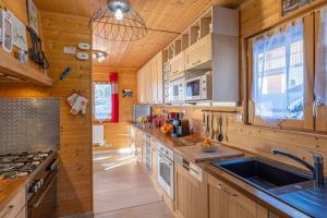 a kitchen with wooden cabinets and a sink and a stove at Duplex - Chalet - 15 personnes in La Toussuire