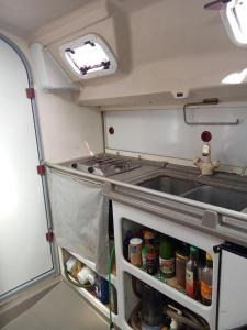 an rv kitchen with a stove and a sink at Chambre sur un voilier in Sainte-Anne