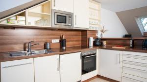 a kitchen with white cabinets and a sink and a microwave at Schöne gemütliche Wohnung in Marl in Marl