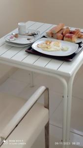 Biały stół z dwoma talerzami jedzenia. w obiekcie Chez Mamanta Studio meublé à St louis w mieście Saint-Louis