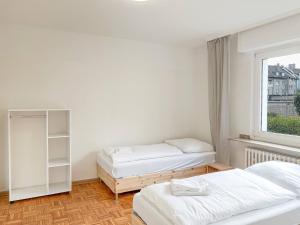 zwei Betten in einem Zimmer mit Fenster in der Unterkunft T&K Apartments - Duisburg - 3 Zimmer Apartment in Duisburg + 3 Fotos