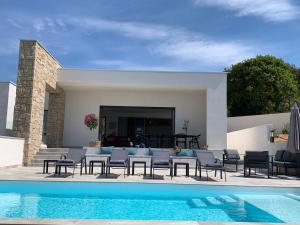 een patio met stoelen en een zwembad bij LES VILLAS DU DOMAINE NAPOLEON CORSICA vue mer et piscine in Pietrosella