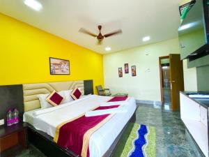 um quarto com uma cama grande e uma parede amarela em Goroomgo Coral Suites Puri Near Sea Beach with Swimming Pool - Parking Facilities em Puri