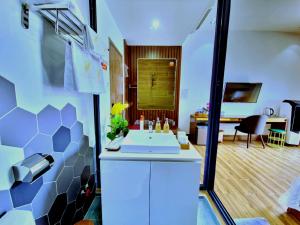 a bathroom with a sink and a room with a desk at THƯ LÊ Hotel in Cao Lãnh