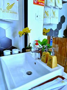 um lavatório branco na casa de banho com um espelho em THƯ LÊ Hotel em Cao Lãnh