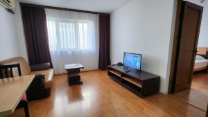 ein Wohnzimmer mit einem TV auf dem Tisch in der Unterkunft Arion Hotel in Constanţa