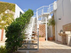 a spiral staircase with a green hedge next to a building at Vacation home with private pool, Floridia in Floridia