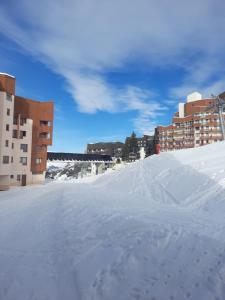 una strada innevata in una città con edifici di Appartement carlines 1 les ménuires a Les Menuires