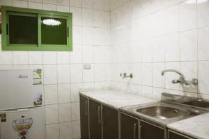 a kitchen with a sink and a counter top at كيان العزيزية للشقق المخدومة - Kayan Al-Azizia Serviced Apartments in Jeddah