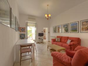 a living room with a red couch and a table at Vacation home with private pool, Floridia in Floridia