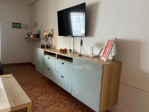 a room with a dresser with a television on the wall at Casa Sol Vistabella Golf Resort in Orihuela