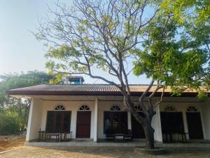 una pequeña casa con un árbol delante en Yala Beach Resort, en Kirinda