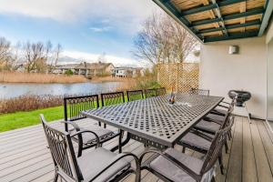 a table and chairs on a deck with a view of a lake at Goslings in Somerford Keynes