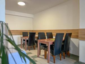 uma sala de conferências com mesas de madeira e cadeiras pretas em AM Motel em Rimavská Sobota