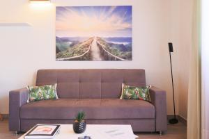 una sala de estar con sofá y una pintura en la pared en Parrots`Village en Rabo de Peixe