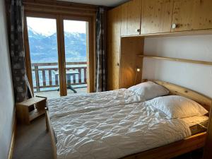 1 dormitorio con 1 cama y vistas a la montaña en Plein Ciel MOUNTAIN & COSY apartments by Alpvision Résidences en Veysonnaz