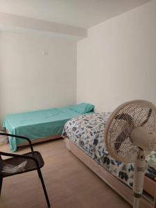 1 dormitorio con 1 cama y 1 silla en una habitación en Casa Agradable con estacionamiento privado, en Santa Marta