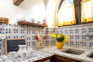 una cucina con piastrelle bianche e blu e un lavandino di Casa con Giardino Pieno Centro Storico a Due Passi dal Duomo a Orvieto