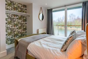a bedroom with a bed and a large window at Goslings in Somerford Keynes