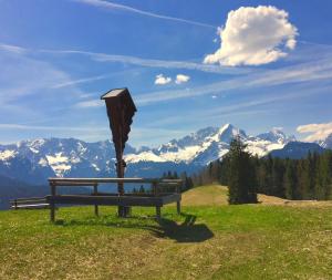 a bench on a hill with a view of mountains at Ferienwohnung Theresia in Garmisch-Partenkirchen