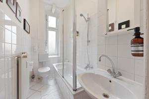 a white bathroom with a sink and a toilet at primeflats - Apartment Kattegat Berlin-Wedding in Berlin