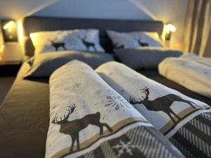 a bed with pillows with deer paintings on it at Ferienwohnung Theresia in Garmisch-Partenkirchen