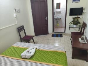 a bedroom with a bed and a desk and a table and chair at Hotel Gamas Inn in Chacka
