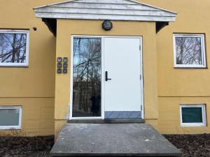 białe drzwi po stronie żółtego domu w obiekcie Sentral leilighet i Gamle Oslo w Oslo