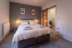 a bedroom with a large bed with two towels on it at Buckingham Court in Cheltenham