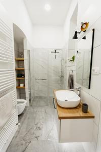 La salle de bains blanche est pourvue d'un lavabo et d'une douche. dans l'établissement Goldsmith's Treasure, à Zagreb