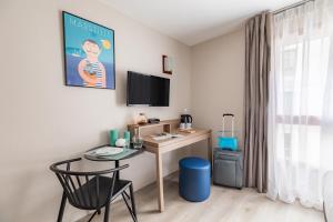 Habitación pequeña con escritorio, mesa y silla. en Appart'City Classic Marseille Euromed, en Marsella