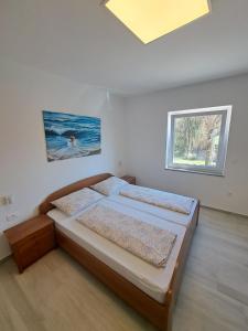 sypialnia z łóżkiem i oknem w obiekcie Apartmani Totić w mieście Malinska