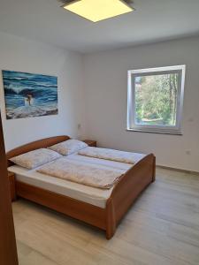 sypialnia z łóżkiem i oknem w obiekcie Apartmani Totić w mieście Malinska