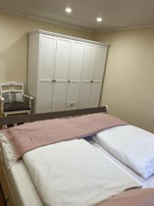 a bedroom with a bed with white cabinets at Ferienwohnung Alida in Niebüll
