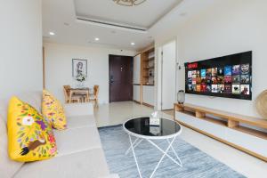 a living room with a couch and a tv at Gem Apartment - VinCom D'Capitale Ha Noi in Hanoi