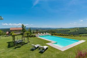 a swimming pool in a yard with chairs and a house at Rosa Dei Venti 8, Emma Villas in Fabro