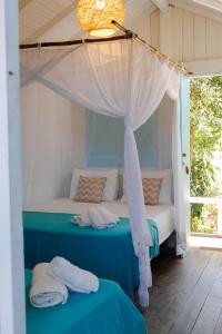 um quarto com uma cama de dossel e 2 toalhas em Encanto Caraíva em Caraíva
